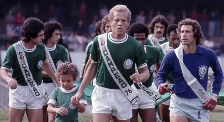 Jogadores do Palmeiras da década de 1976, ao centro da imagem, Ademira da Guia, vestindo camisa do time com faixa de Campeão de 1976, no gramado do Palestra Itália.