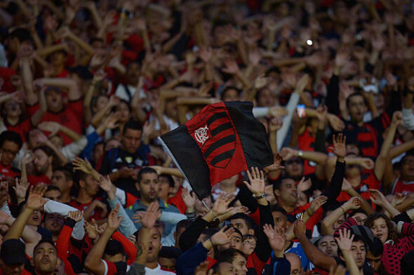 Torcida do Flamengo lotando arquibancada e bandeira do time erguida por torcedor