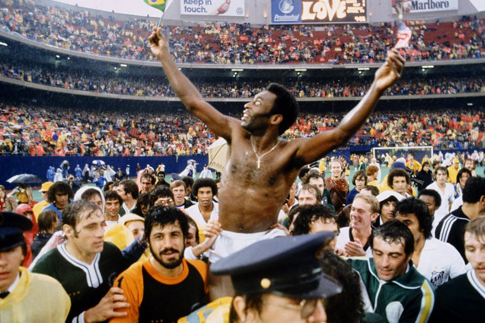 Pelé, sem camisa, erguido por multidão, após jogar sua última partida como jogador profissional