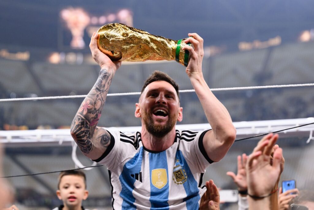 Lionel Messi comemora o título da Copa do Mundo erguendo a taça em suas mãos