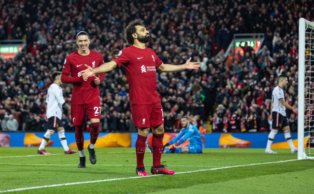 Liverpool massacra o Manchester United em dia inspirado de Salah, que na imagem comemora com a torcida em Anfield
