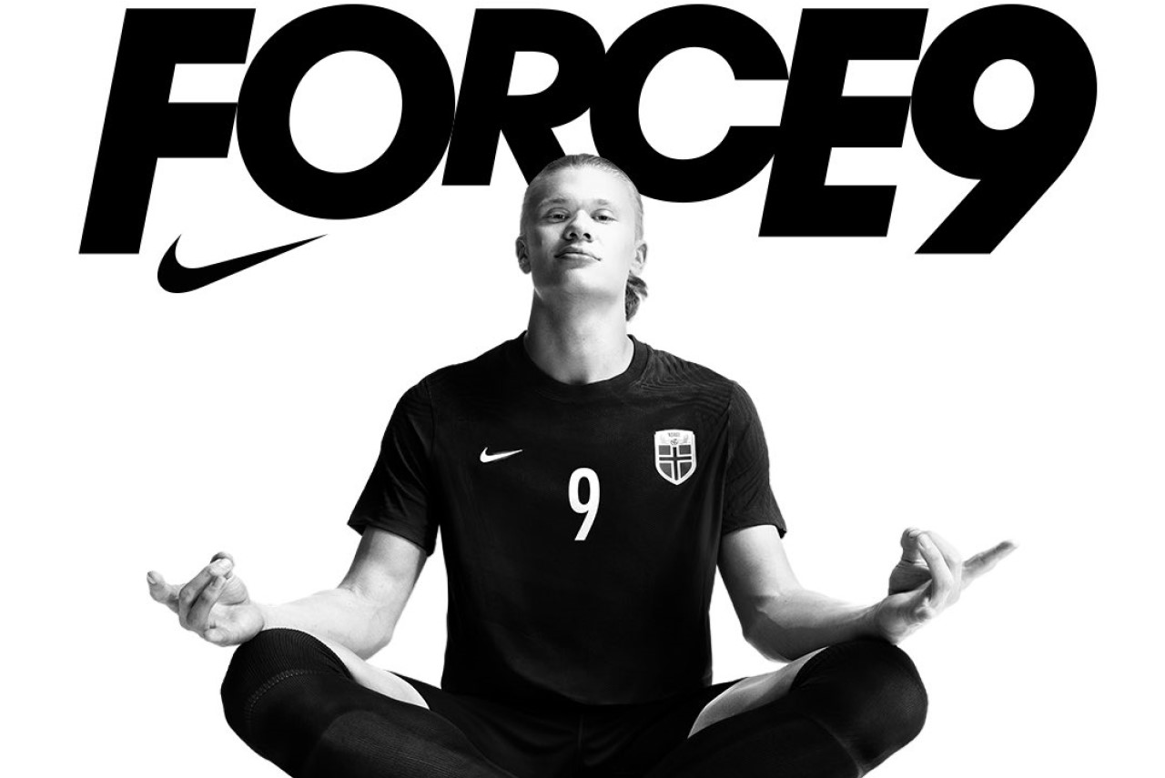 Haaland e Nike: Atacante assina o 2º maior contrato de patrocínio do futebol - Haaland está sentado, de pernas cruzadas, como se estivesse meditando. Essa é a sua comemoração habitual nos gols e, atrás dele, há o símbolo da Nike com a palavra "Force 9"