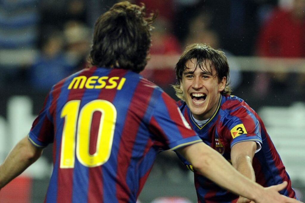 Bojan anuncia aposentadoria: Lionel Messi, de costas, e Bojan Krkic, de frente, correm para se abraçar em comemoração a gol