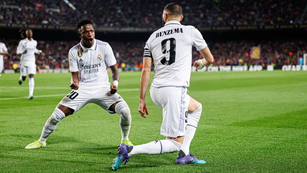 Real Madrid goleia o Barcelona. Os dois jogadores estão comemorando o gol. Eles usam uniforme branco em detalhes em preto. Foto: Reprodução/Twitter Real Madrid