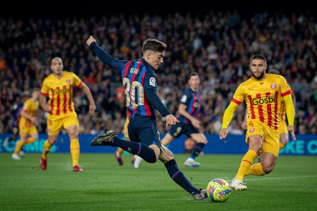 Barcelona empata com o Girona, mas amplia vantagem na liderança da La Liga - Gavi tenta cruzamento pelo lado direito de campo, enquanto que a marcação do Girona o acompanha