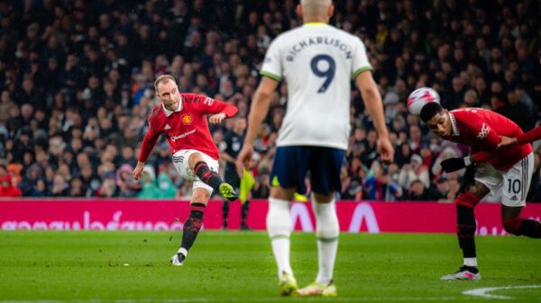 Tottenham e Manchester United empatam em jogão pela Premier League - Eriksen, do Manchester United, finaliza para o gol. A bola bate em Rashford, seu companheiro de equipe. Enquanto que Richarlison, do Tottenham, está de costas para a câmera e observa o lance.