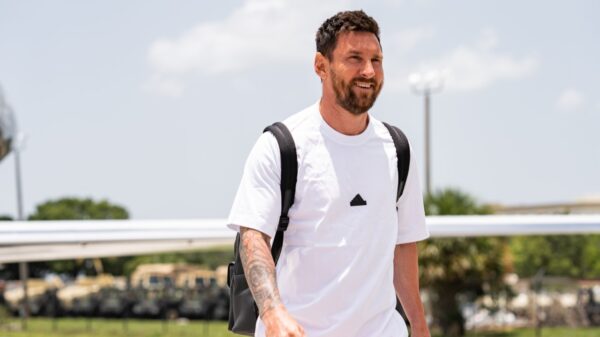 Messi vai ser emprestado pelo Inter Miami? Jornalista revela planos do craque - Messi usa uma camisa branca com a logo da adidas ao centro dela, enquanto usa uma mochila nas costas e caminha sorridente