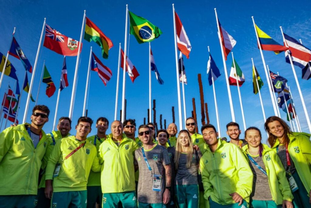 Delegação brasileira posa em frente à bandeira brasileira no Pan-Americano de Santiago 2023
