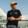 Piloto Gabriel Bortoleto posa com boné da McLaren e camisa da Virtuosi no GP de Abu Dhabi 2023