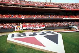 Escudo do São Paulo no Morumbi e, ao fundo, torcida do São Paulo lota arquibancada