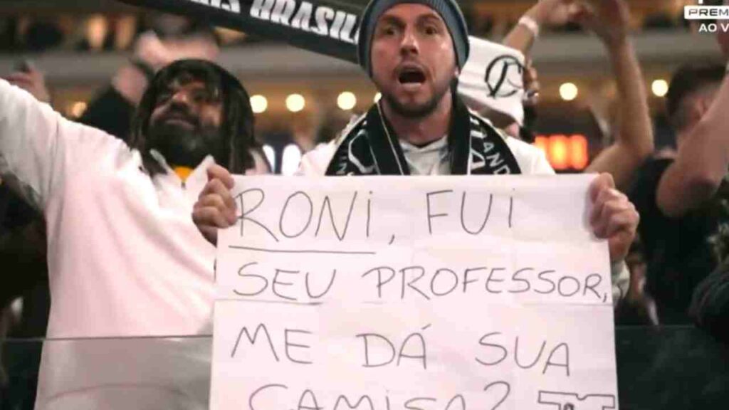 Ex-professor de Roni leva cartaz para a Arena Corinthians e ganha camisa do jogador