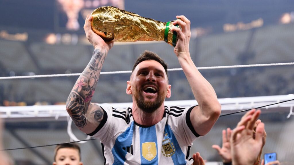 Lionel Messi comemora o título da Copa do Mundo erguendo a taça em suas mãos