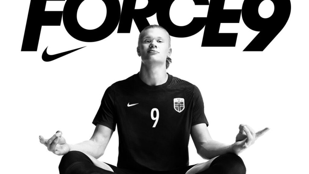 Haaland e Nike: Atacante assina o 2º maior contrato de patrocínio do futebol - Haaland está sentado, de pernas cruzadas, como se estivesse meditando. Essa é a sua comemoração habitual nos gols e, atrás dele, há o símbolo da Nike com a palavra "Force 9"