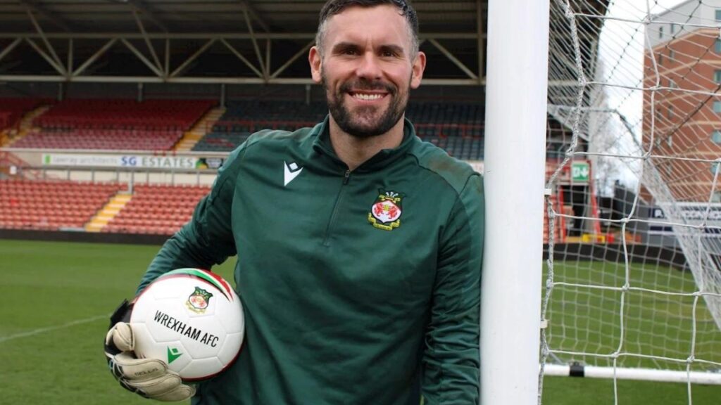 Ben Foster no time de Ryan Reynolds: Goleiro Ben Foster, do Wrexham, segurando uma bola, apoiado em trave