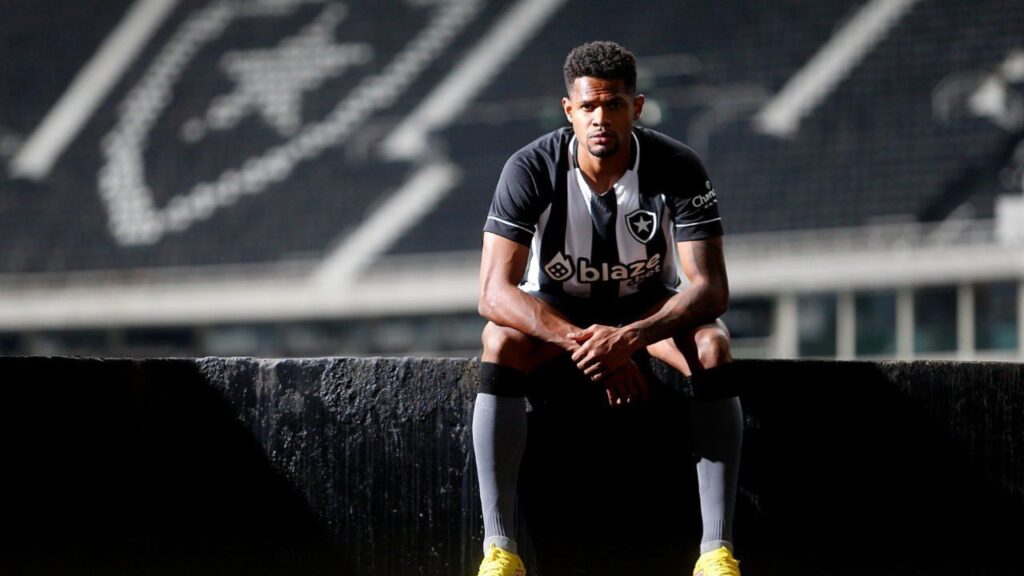 Júnior Santos posa para fotografia, com estádio do Botafogo ao fundo