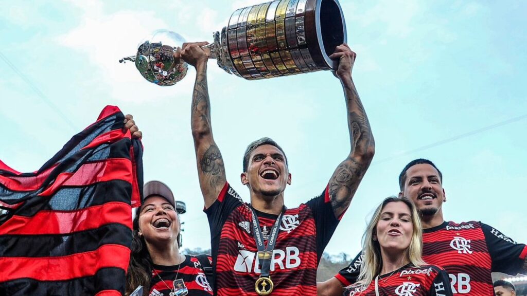 Libertadores 2023: Atacante Pedro com a medalha de campeão da Copa Libertadores, levanta taça e comemora o título com outras pessoas
