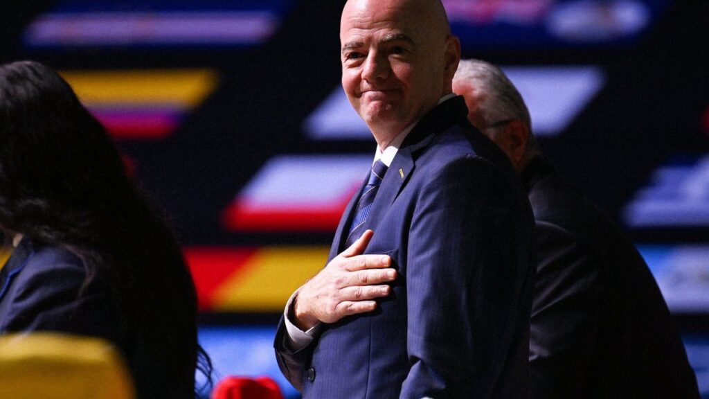 Infantino é reeleito presidente da Fifa: Gianni Infantino, presidente da Fifa, no Congresso da Fifa 2022, com a mão sob o peito e bandeiras ao fundo