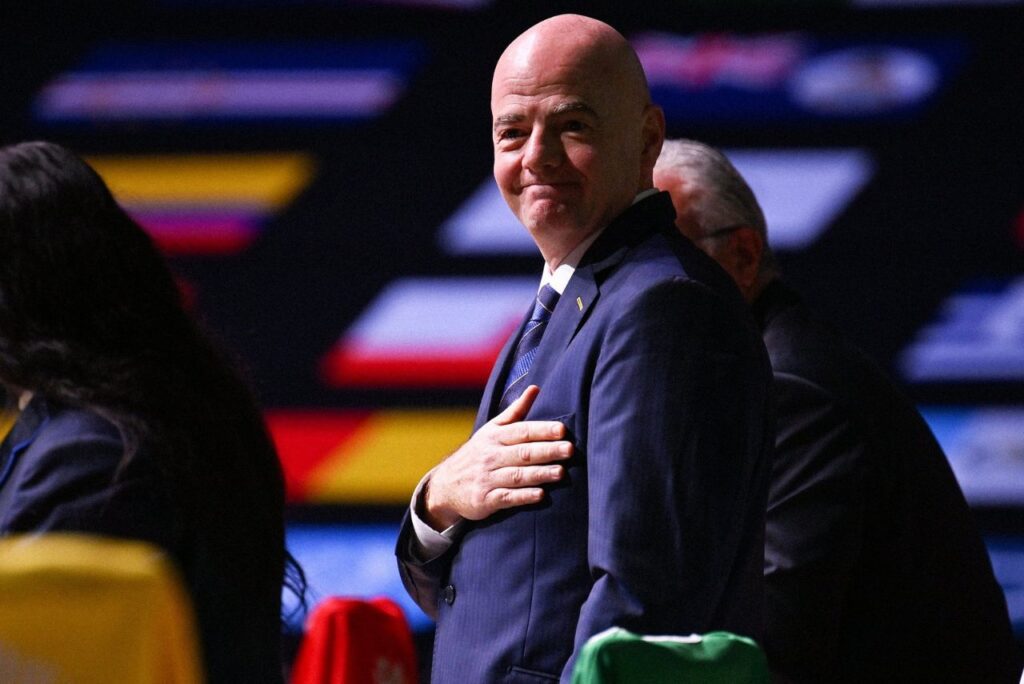 Infantino é reeleito presidente da Fifa: Gianni Infantino, presidente da Fifa, no Congresso da Fifa 2022, com a mão sob o peito e bandeiras ao fundo