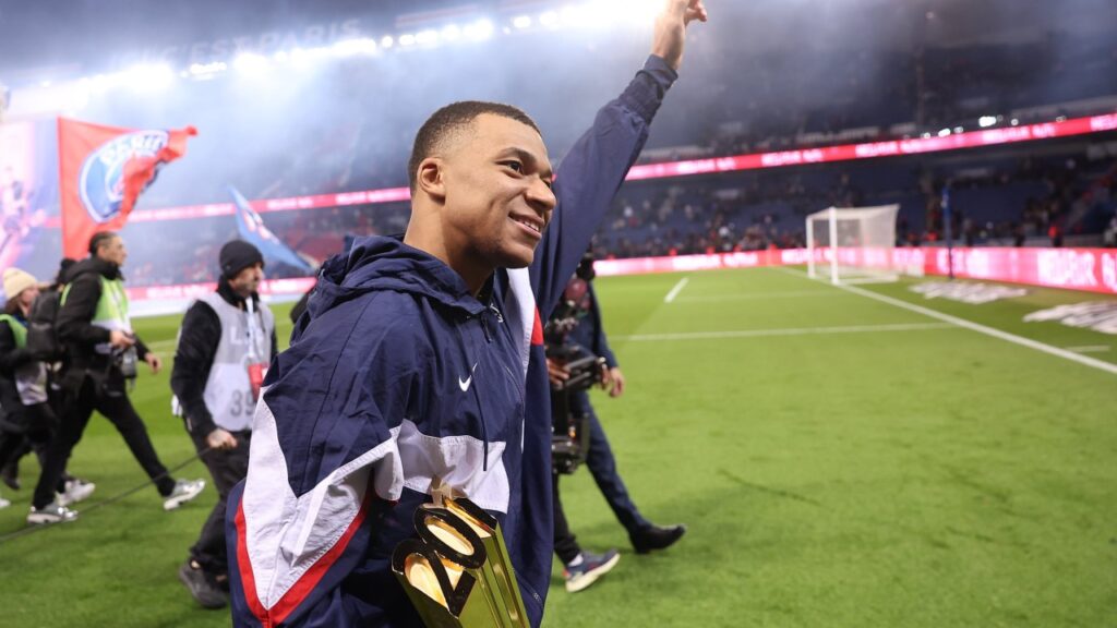 Mbappé é o maior artilheiro do PSG na história após marcar em vitória na Ligue 1 - Mbappé anda ao redor do gramado ao fim do jogo do PSG, com um troféu que o clube fez para homenageá-lo por ter se tornado o maior artilheiro do PSG na história.