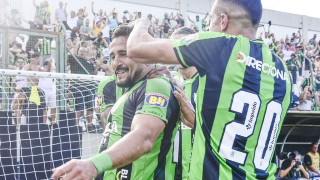 América vence o Cruzeiro: Aloísio, do América-MG, comemora gol contra o Cruzeiro com outros jogadores na Arena do Jacaré