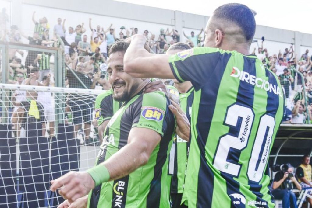 América vence o Cruzeiro: Aloísio, do América-MG, comemora gol contra o Cruzeiro com outros jogadores na Arena do Jacaré