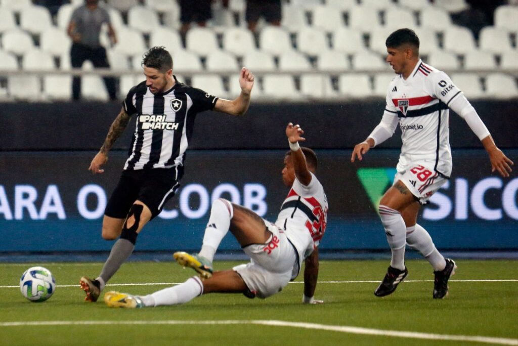 Botafogo vence o São Paulo: Gustavo Sauer, do Botafogo, finaliza em frente a Caio Paulista, do São Paulo, chegando de carrinho ao lado de Alan Franco