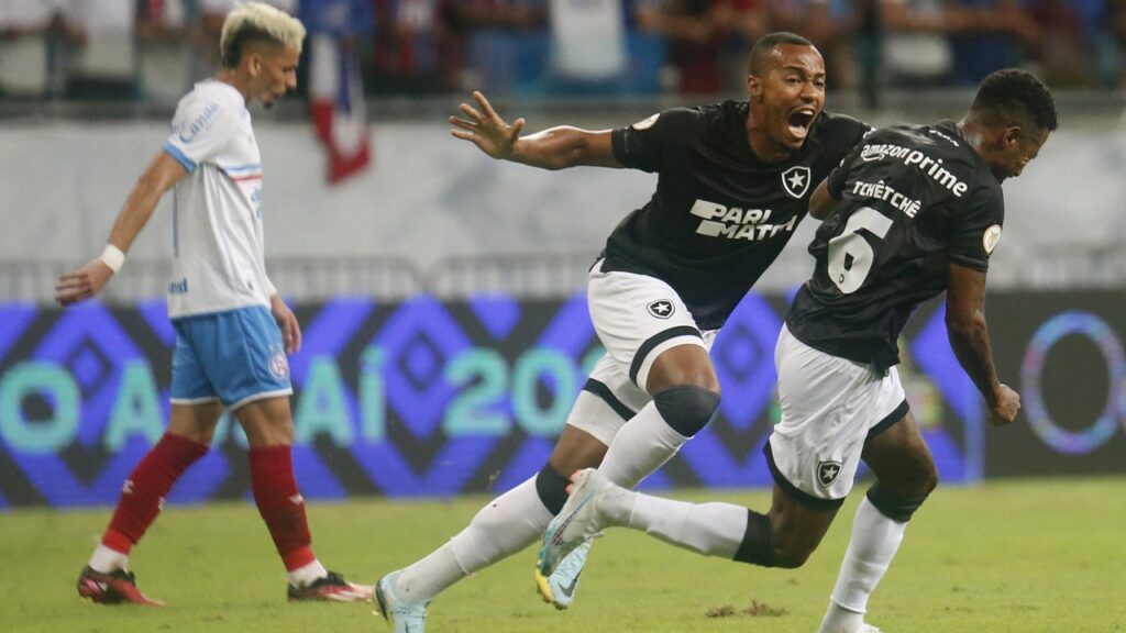 Botafogo vence o Bahia fora de casa e segue 100% no Brasileirão - Marlon Freitas corre para abraçar Tchê Tchê, autor do gol do Botafogo, enquanto que um jogador do Bahia, cabisbaixo, lamenta o gol sofrido