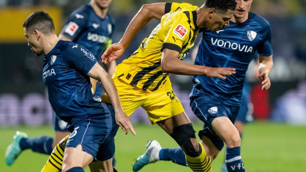 Borussia Dortmund empata com o Bochum e pode perder liderança da Bundesliga para o Bayern - Jude Bellingham tenta passar entre 2 adversários do Bochum em jogo pela Bundesliga