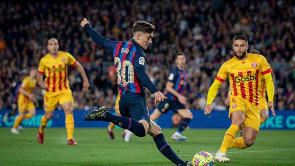 Barcelona empata com o Girona, mas amplia vantagem na liderança da La Liga - Gavi tenta cruzamento pelo lado direito de campo, enquanto que a marcação do Girona o acompanha