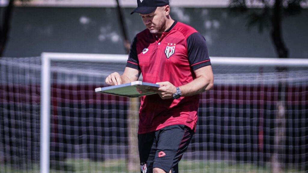 Mirassol demite Ricardo Catalá: Mozart, ex-técnico do Atlético-GO, comandava treino no clube em campo do CT com o uniforme vermelho e preto, com boné, além de ter uma prancheta em mãos, num dia ensolarado.