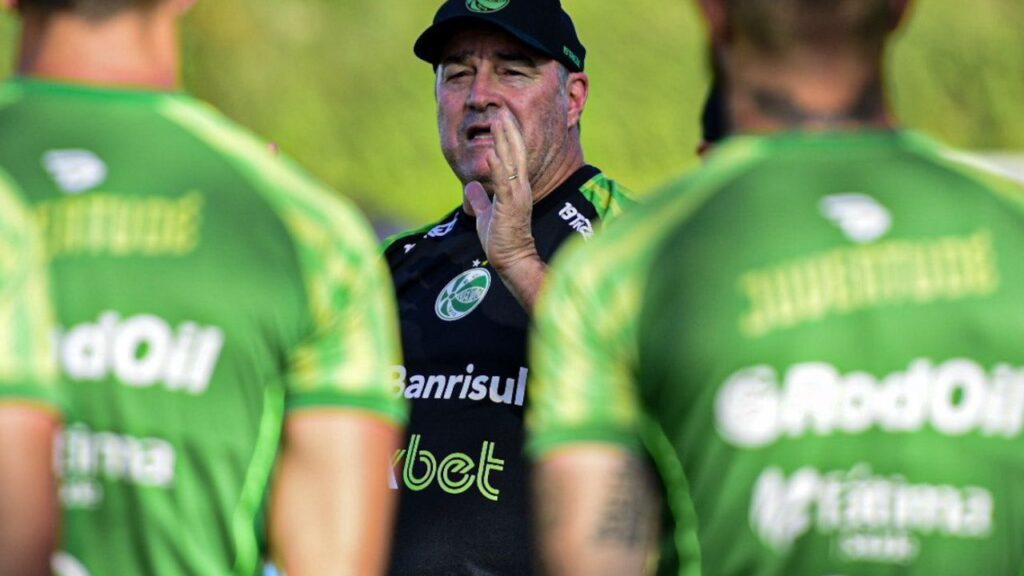 Treinador Pintado aparece de frente, entre jogadores de costas, em treino do Juventude em 2023