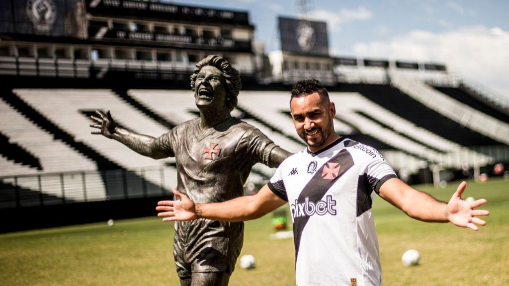 Dimitri Payet, do Vasco da Gama, posa ao lado da estátua de Roberto Dinamite em São Januário