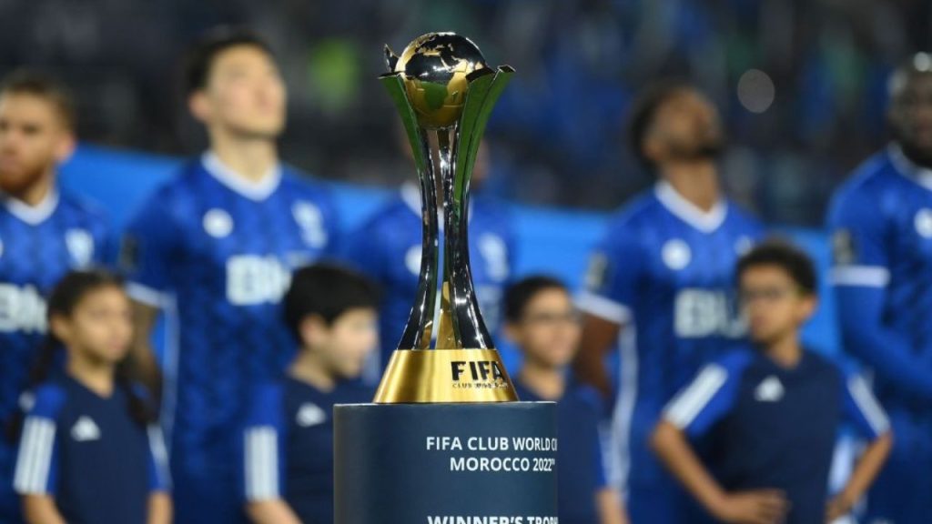 Taça do Mundial de Clubes de 2022, com elenco do Al-Hilal ao fundo