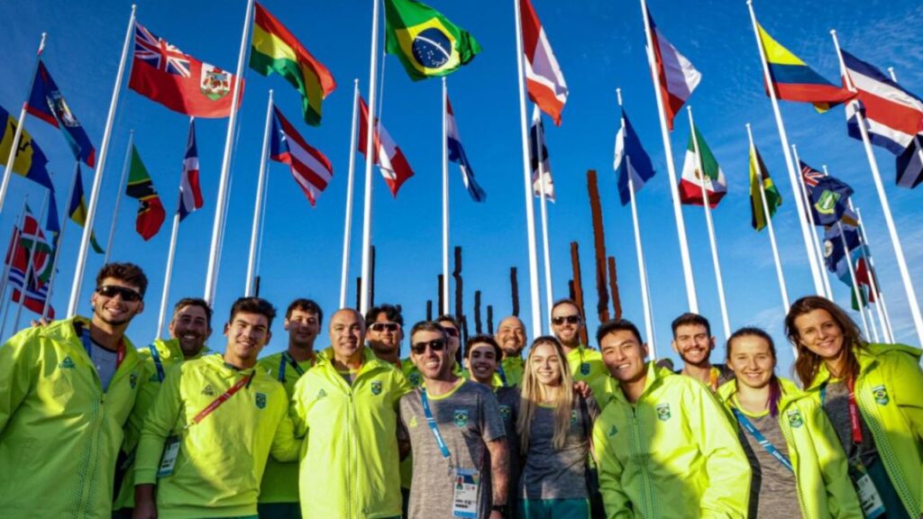 Delegação brasileira posa em frente à bandeira brasileira no Pan-Americano de Santiago 2023